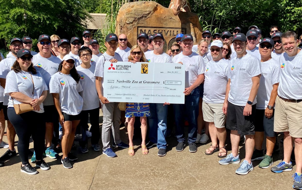 Group of people from the Nashville Zoo holding a check from Mitsubishi Electric.