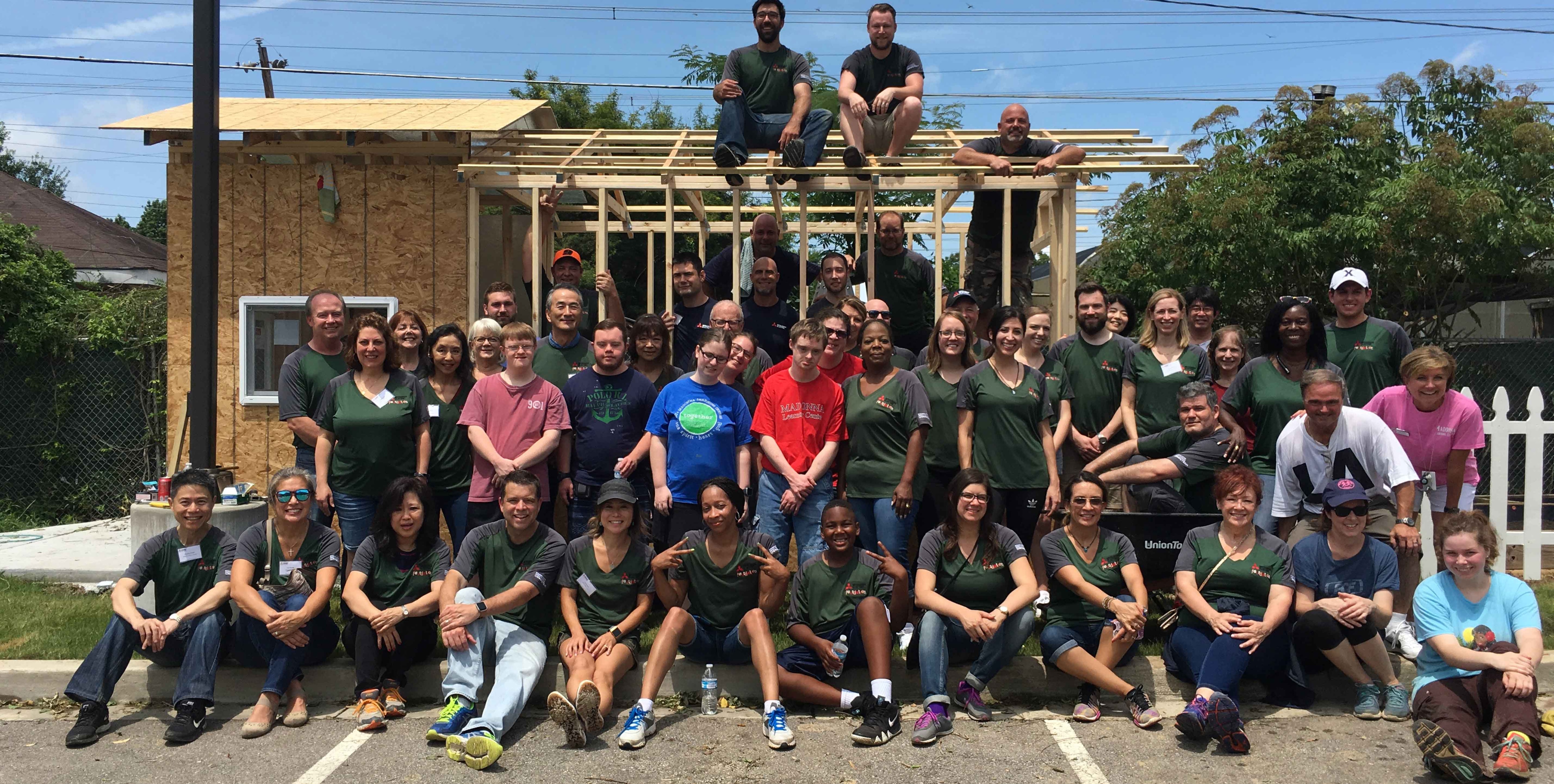 Large inclusive community group, building a house together.