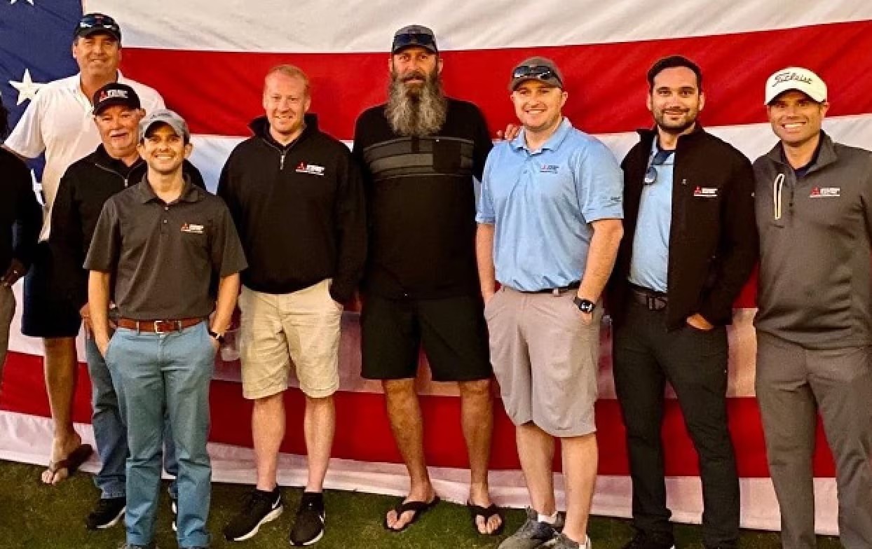 Veterans standing in front of american flag